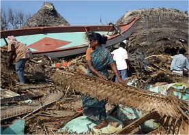 Fisherfolk family in Tamil Nadu picking through the remains of their home