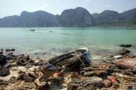 A tsunami-battered fishing boat lies on a beach on Thailand's island of Phi Phi, January 2, 2005, Reuters/Bazuki Muhammad 